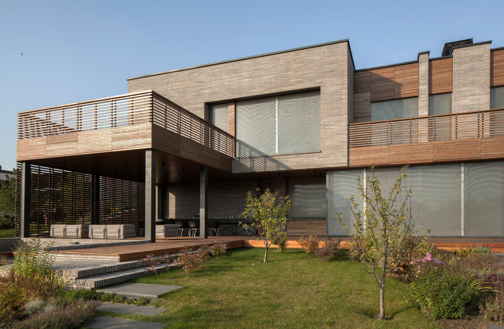 Пример оригинального дизайна: большой, двухэтажный, серый частный загородный дом в стиле модернизм с облицовкой из бетона и плоской крышей
