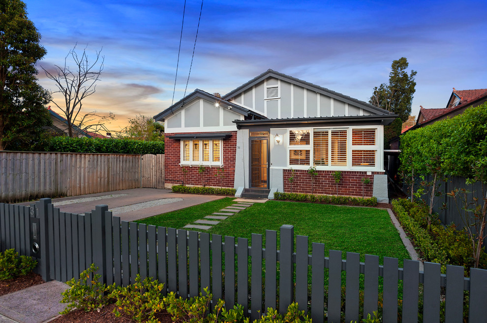 Photo of a small and gey traditional two floor brick house exterior in Sydney with a pitched roof.