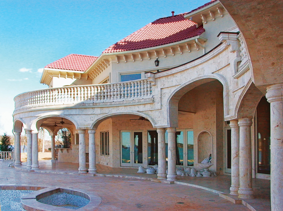 Foto della facciata di una casa ampia mediterranea a due piani con rivestimento in pietra