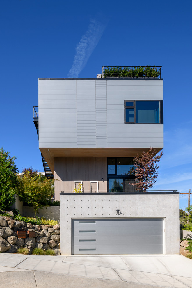Стильный дизайн: трехэтажный, серый частный загородный дом среднего размера в стиле модернизм с облицовкой из бетона, плоской крышей и крышей из смешанных материалов - последний тренд