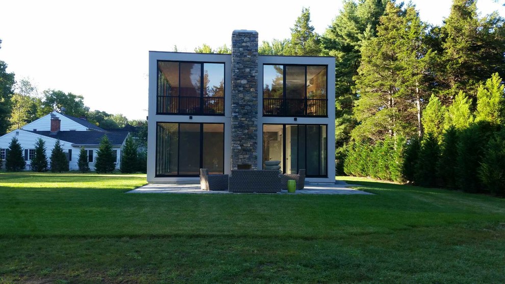 Идея дизайна: двухэтажный, серый частный загородный дом среднего размера в стиле модернизм с облицовкой из цементной штукатурки и плоской крышей