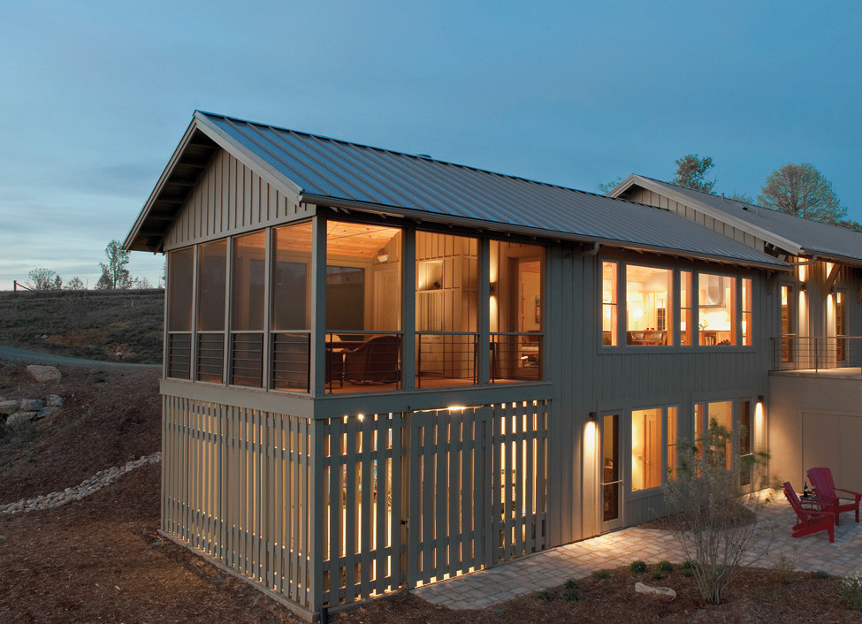 Стильный дизайн: двухэтажный, деревянный, коричневый частный загородный дом среднего размера в стиле модернизм с двускатной крышей и металлической крышей - последний тренд