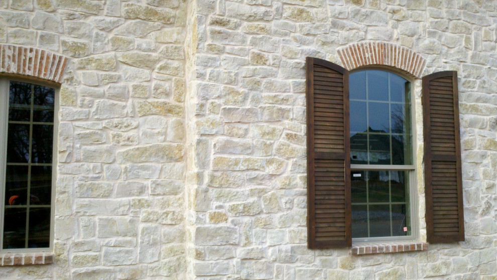 Modelo de fachada de casa beige clásica de dos plantas con revestimiento de piedra