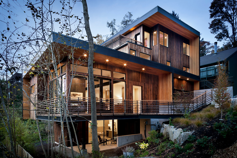 Imagen de fachada minimalista grande de tres plantas con revestimiento de madera y tejado plano