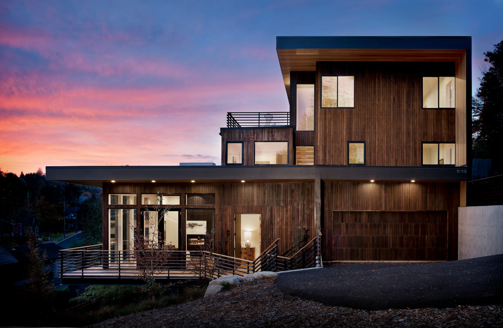 Cette photo montre une grande façade de maison moderne en bois à deux étages et plus avec un toit plat.