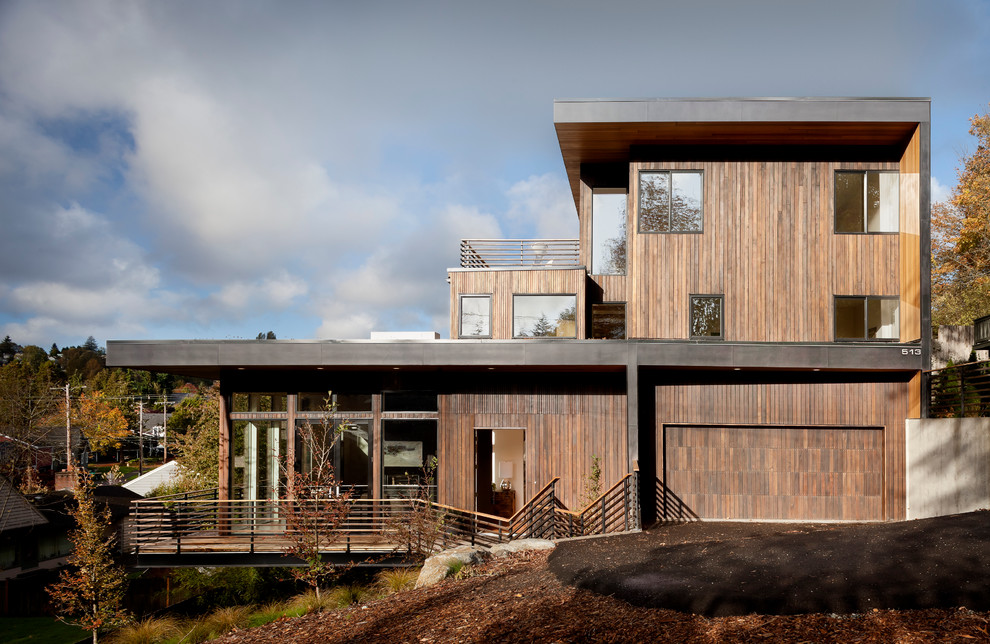 Inspiration for a large modern house exterior in Seattle with three floors, wood cladding and a flat roof.
