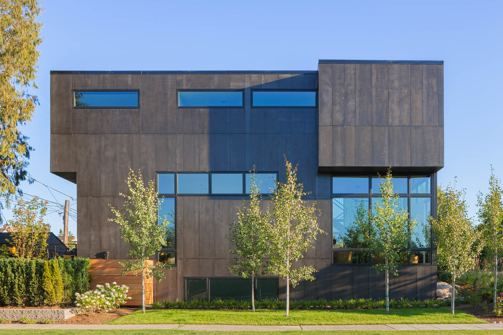 Пример оригинального дизайна: двухэтажный, серый дом в современном стиле с облицовкой из металла и плоской крышей