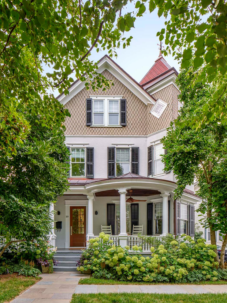 Mid-sized ornate white three-story stucco exterior home photo in Philadelphia with a shingle roof