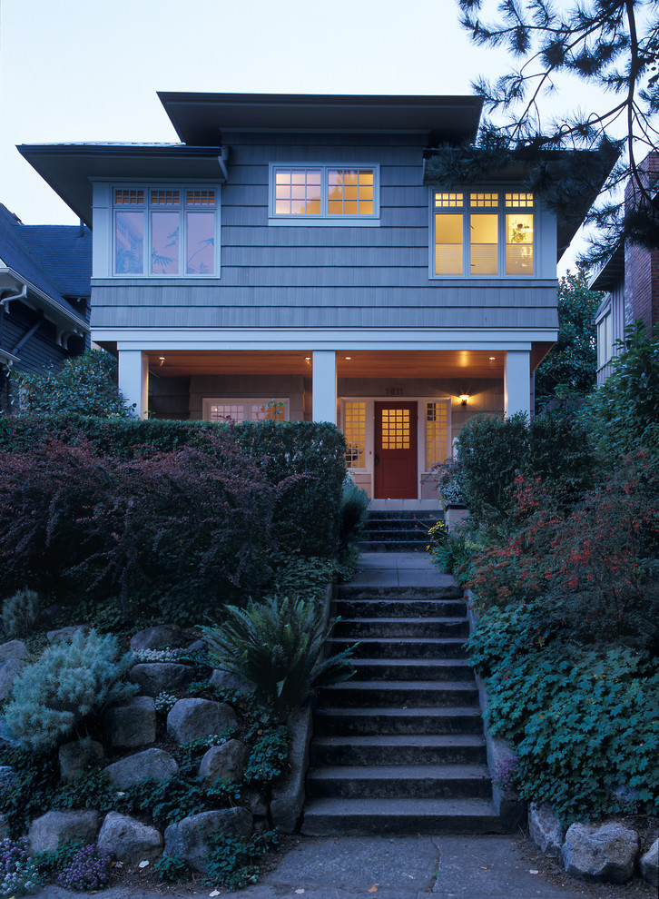 Idee per la facciata di una casa grigia american style a due piani con rivestimento in legno, tetto a padiglione e scale