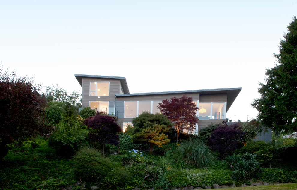 Idées déco pour une façade de maison grise contemporaine à niveaux décalés avec un revêtement mixte.