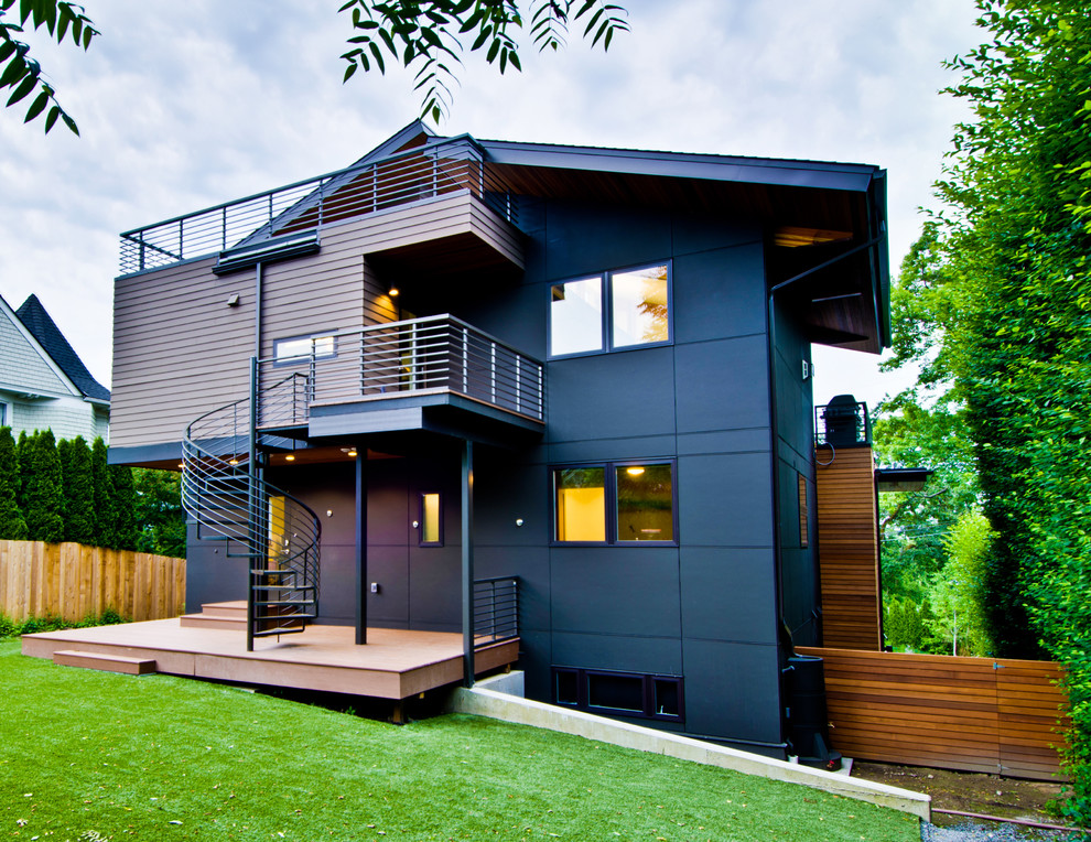 Exemple d'une grande façade de maison verte moderne en bois à deux étages et plus.