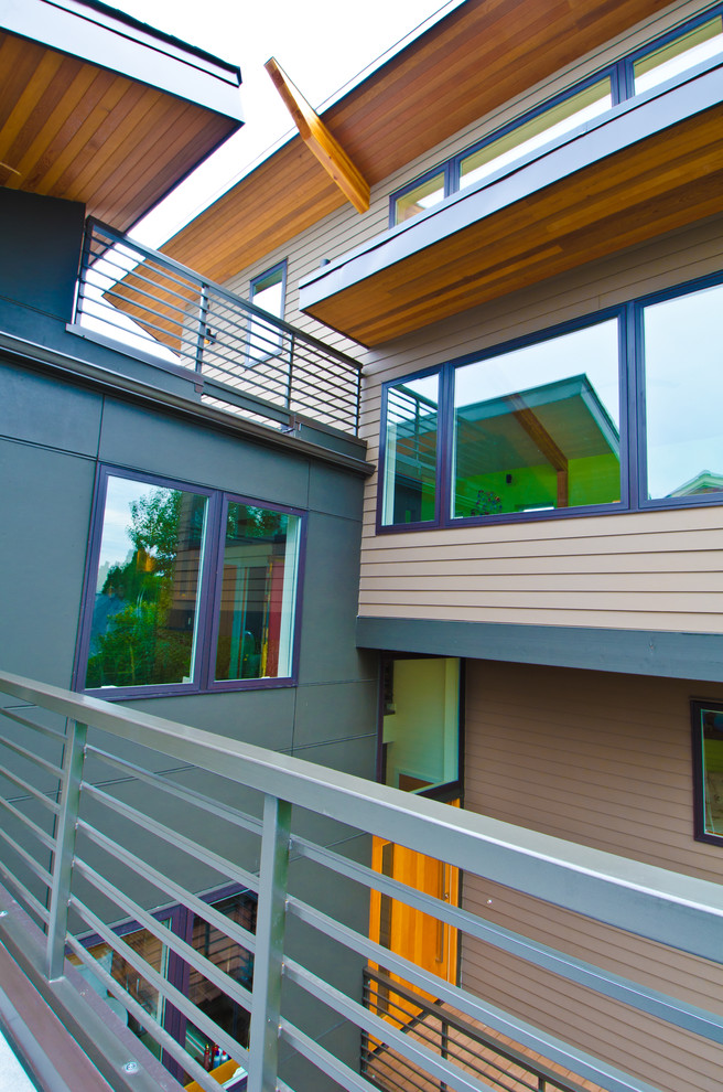 Réalisation d'une grande façade de maison marron minimaliste en bois à deux étages et plus avec un toit en appentis.
