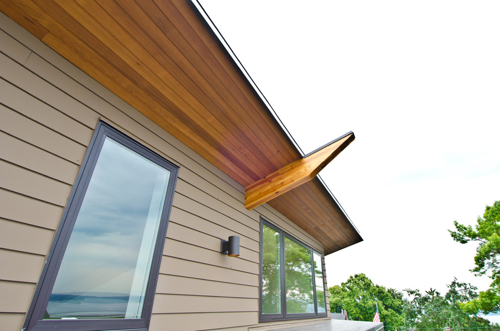 Aménagement d'une grande façade de maison marron moderne en bois à deux étages et plus avec un toit en appentis.