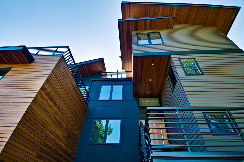 Photo of a large and green modern house exterior in Seattle with three floors, wood cladding and a lean-to roof.