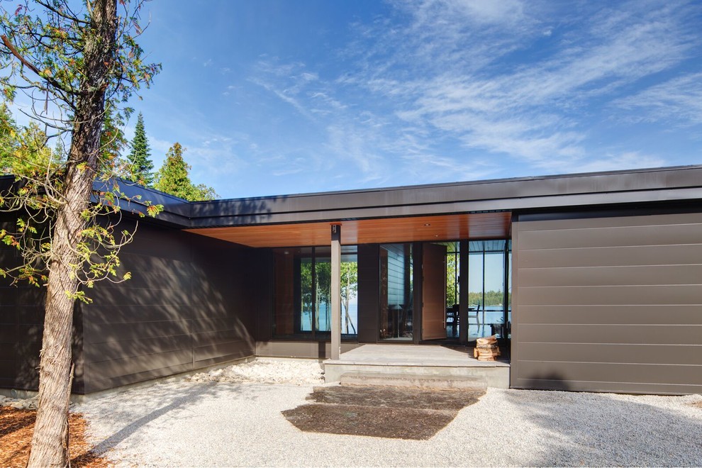 Идея дизайна: большой, одноэтажный, коричневый частный загородный дом в стиле модернизм с облицовкой из металла и плоской крышей