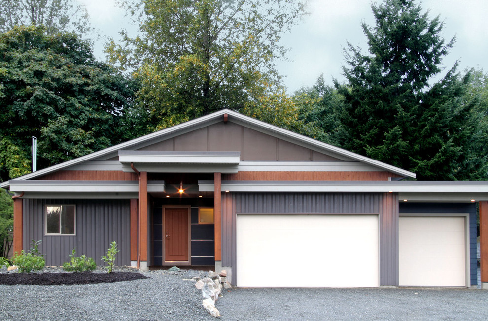 Exemple d'une façade de maison métallique et bleue tendance de taille moyenne et de plain-pied avec un toit à deux pans et un toit en métal.