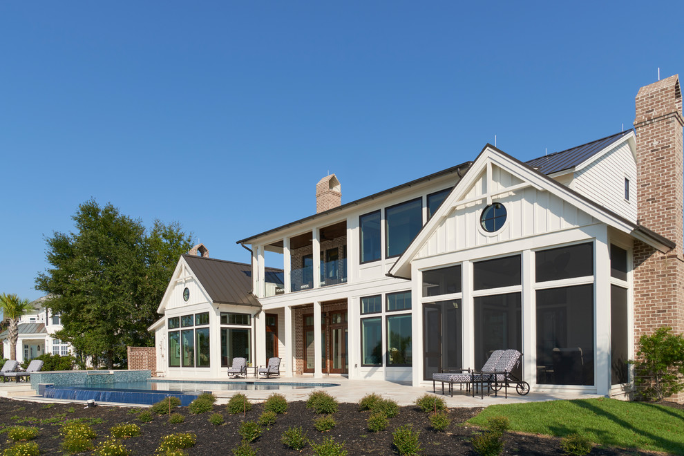 Foto della facciata di una casa bianca stile marinaro con rivestimenti misti e tetto a capanna