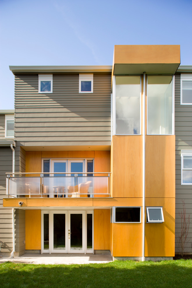 Inspiration pour une façade de maison grise design à deux étages et plus avec un revêtement mixte.