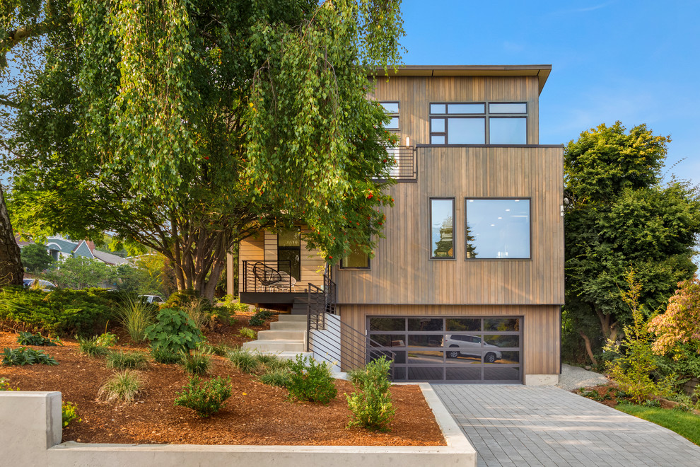 Diseño de fachada de casa marrón contemporánea de tamaño medio de tres plantas con revestimiento de madera, tejado plano y tejado de metal