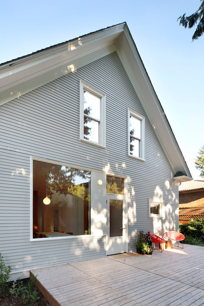 Modelo de fachada de casa gris clásica renovada de tamaño medio de dos plantas con revestimiento de madera, tejado a dos aguas y tejado de teja de madera
