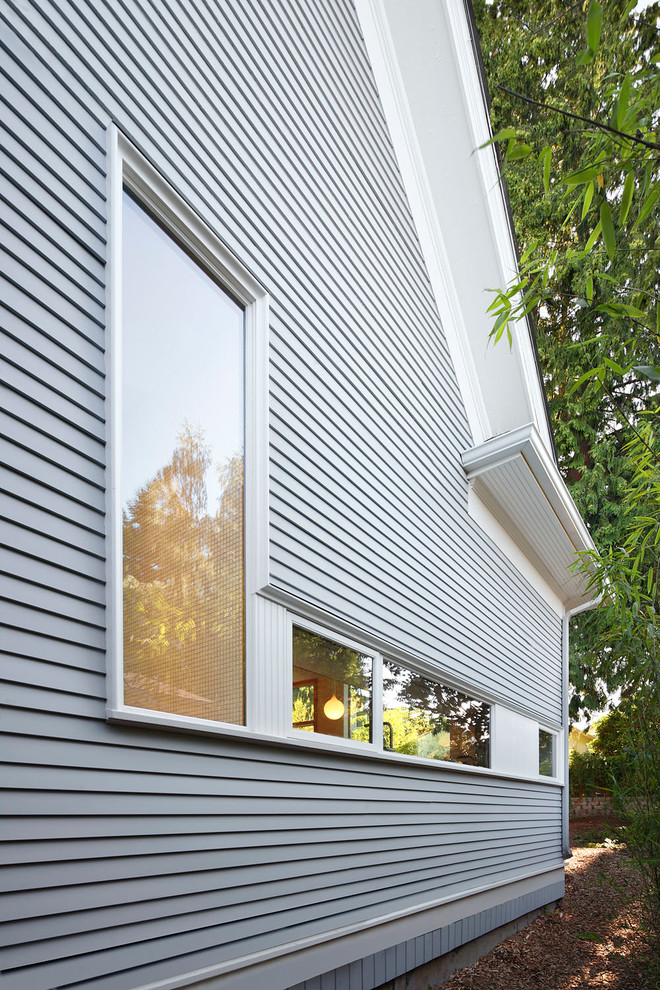 Diseño de fachada de casa gris clásica renovada de tamaño medio de dos plantas con revestimiento de madera y tejado a dos aguas