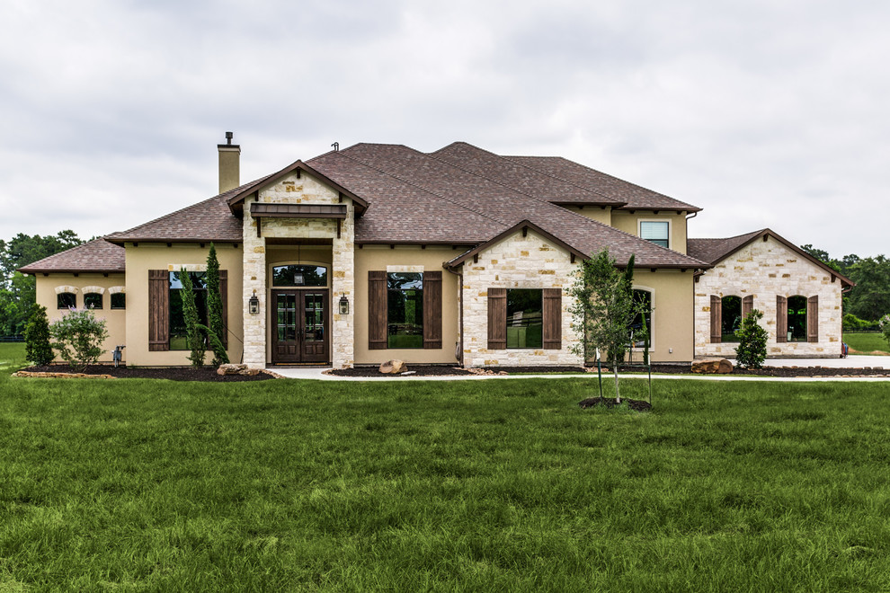 Geräumiges, Zweistöckiges Klassisches Einfamilienhaus mit Mix-Fassade, beiger Fassadenfarbe, Walmdach und Schindeldach in Houston