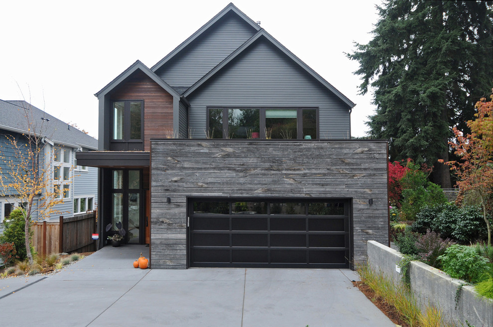 Design ideas for a contemporary house exterior in Seattle with wood cladding and a pitched roof.
