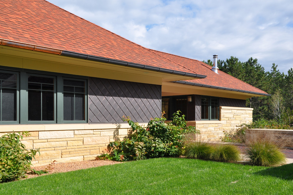 Modelo de fachada beige de estilo americano grande de una planta con revestimiento de metal y tejado a cuatro aguas