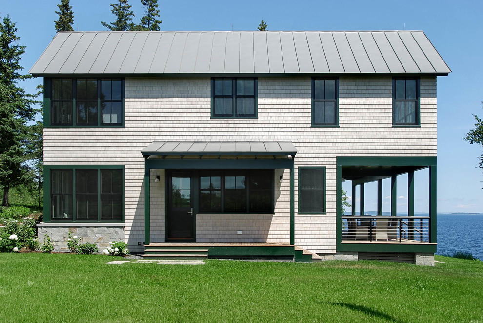 На фото: большой, двухэтажный, деревянный, серый дом в морском стиле с двускатной крышей