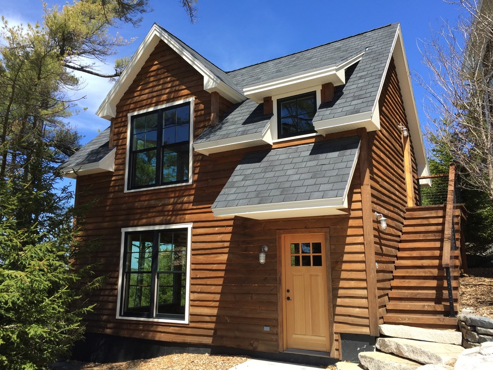 Стильный дизайн: двухэтажный, деревянный, коричневый дом в стиле рустика с двускатной крышей - последний тренд