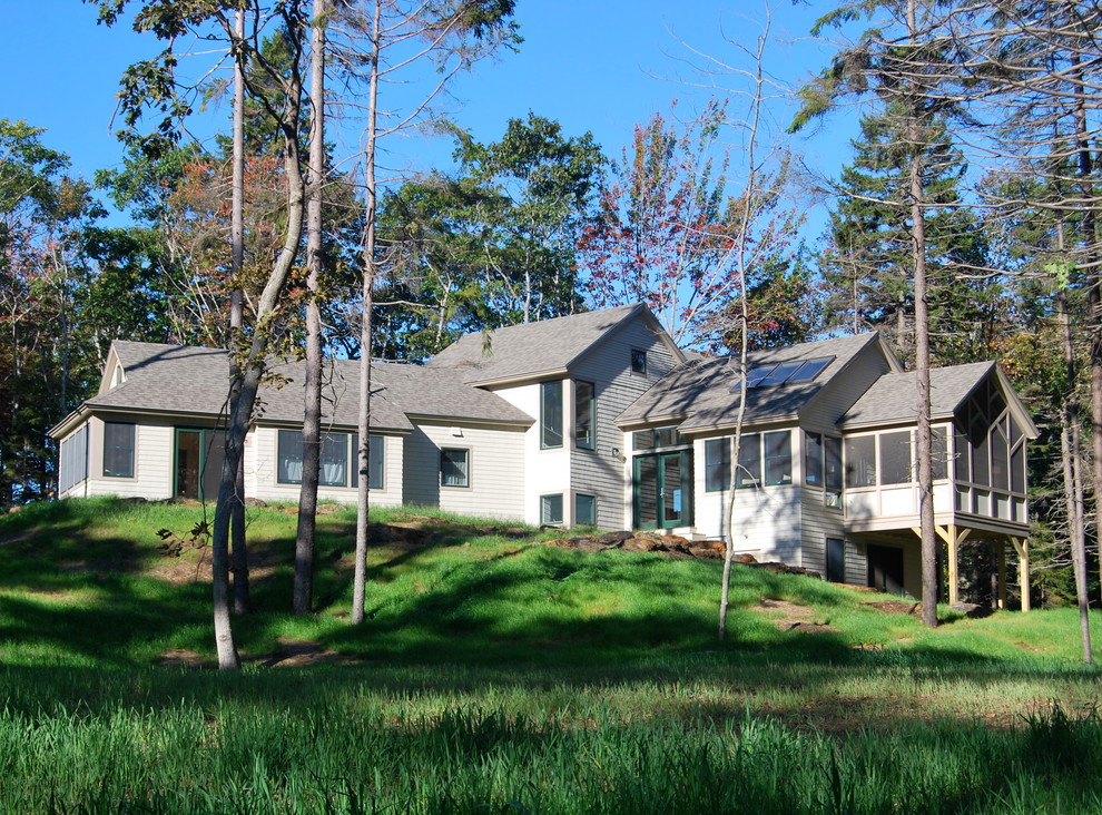 Ejemplo de fachada de casa beige rural de tamaño medio de dos plantas con revestimiento de madera, tejado a dos aguas y tejado de teja de madera