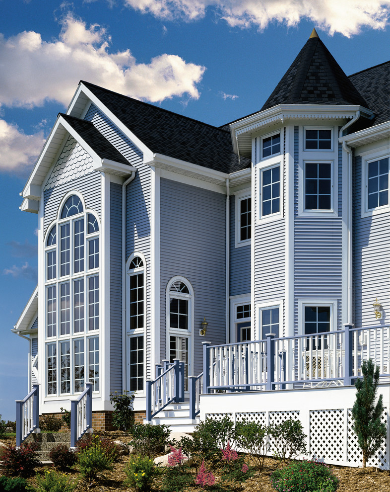 Пример оригинального дизайна: трехэтажный, синий дом среднего размера в морском стиле с облицовкой из винила