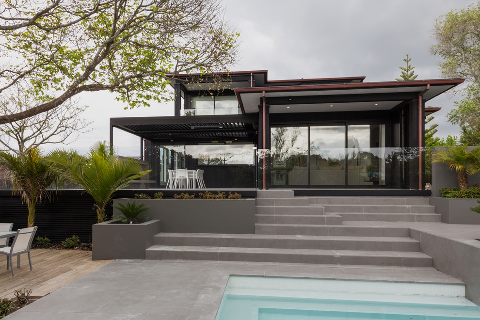 Diseño de fachada negra actual de tamaño medio de dos plantas con revestimiento de vidrio