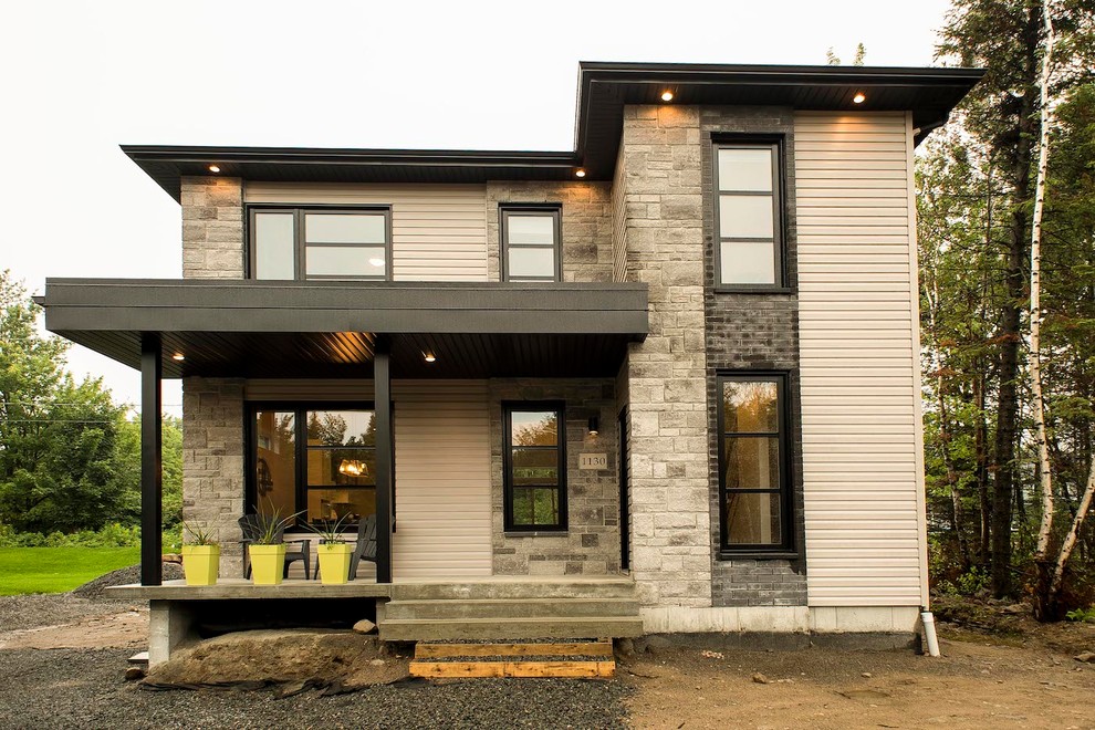 Mittelgroßes, Zweistöckiges Modernes Haus mit Mix-Fassade, grauer Fassadenfarbe und Flachdach in Montreal