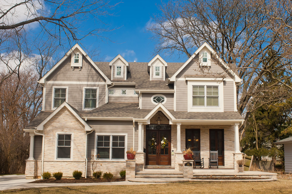 Exemple d'une grande façade de maison beige chic à un étage avec un revêtement mixte et un toit à deux pans.