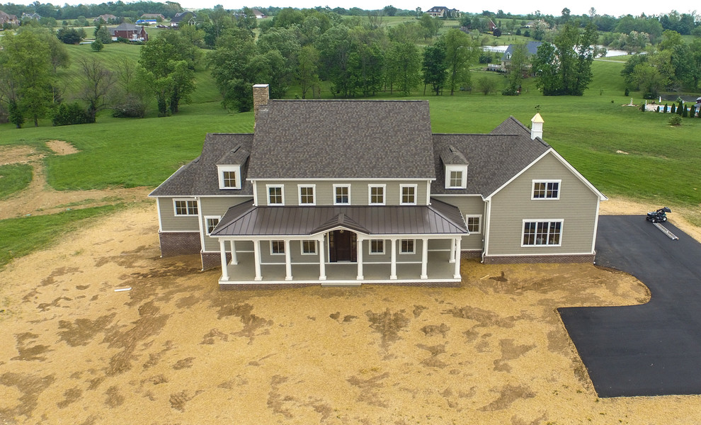 Esempio della facciata di una casa grande beige country a due piani con rivestimento con lastre in cemento