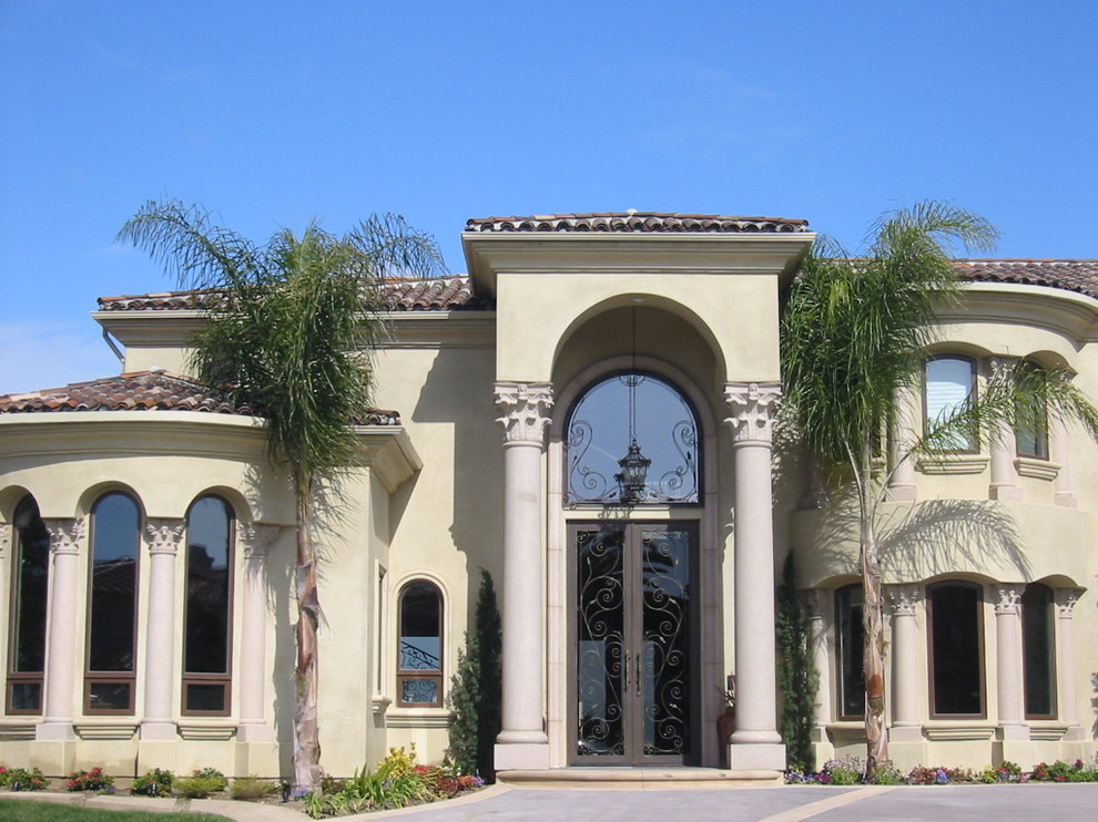 Inspiration for an expansive and beige mediterranean render detached house in Orange County with three floors, a half-hip roof and a tiled roof.