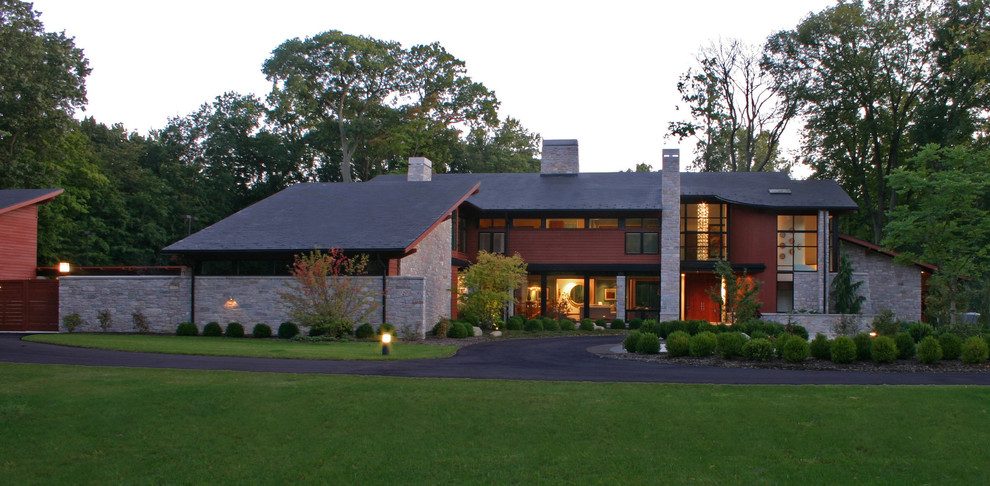 Ejemplo de fachada de casa roja minimalista grande de dos plantas con tejado de un solo tendido, revestimientos combinados y tejado de teja de madera