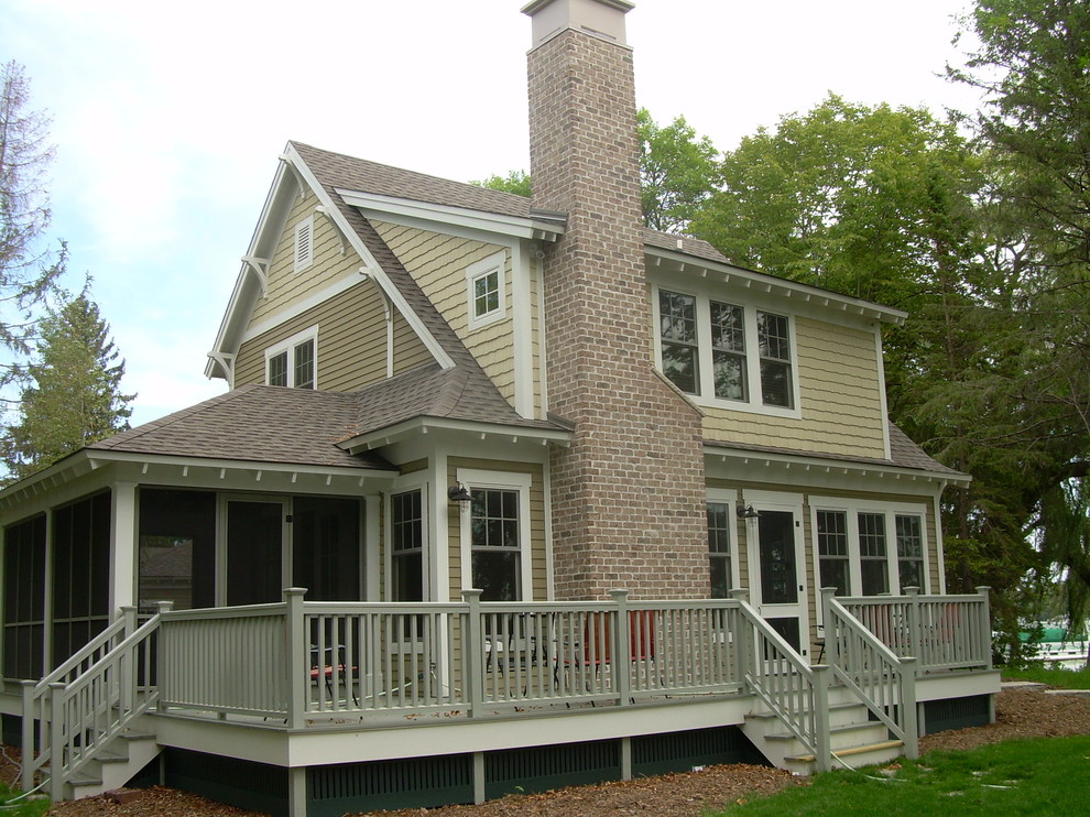 Example of a mid-sized classic yellow two-story wood exterior home design in Milwaukee with a shingle roof