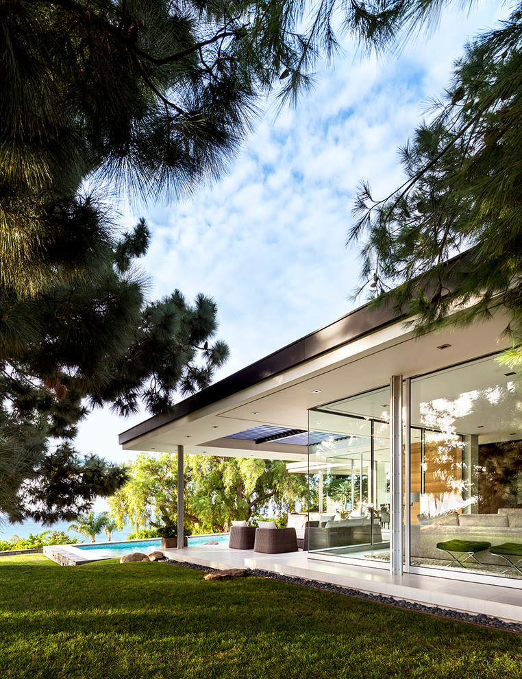 Large and multi-coloured retro bungalow glass detached house in Los Angeles with a flat roof.
