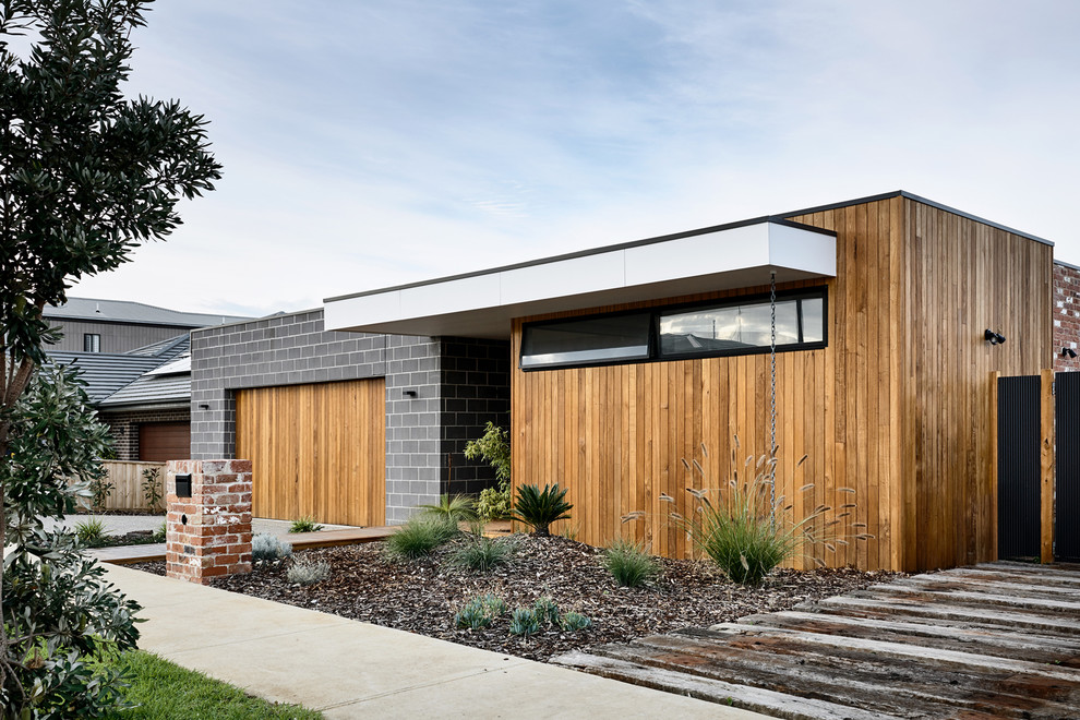 Cette photo montre une façade de maison tendance de plain-pied avec un revêtement mixte et un toit plat.