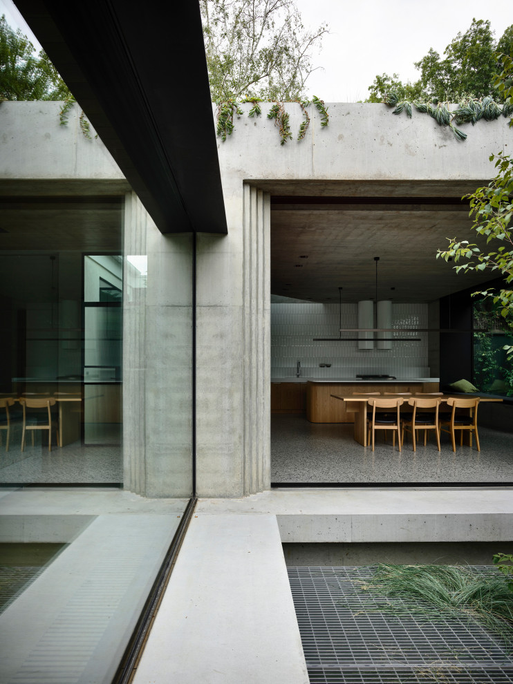 Стильный дизайн: большой, одноэтажный, серый частный загородный дом с облицовкой из бетона, плоской крышей и зеленой крышей - последний тренд