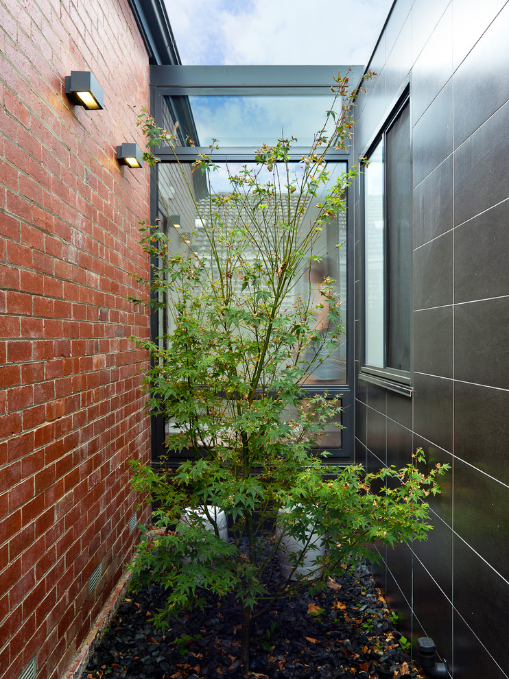 Modernes Haus mit Mix-Fassade, grauer Fassadenfarbe und Flachdach in Melbourne