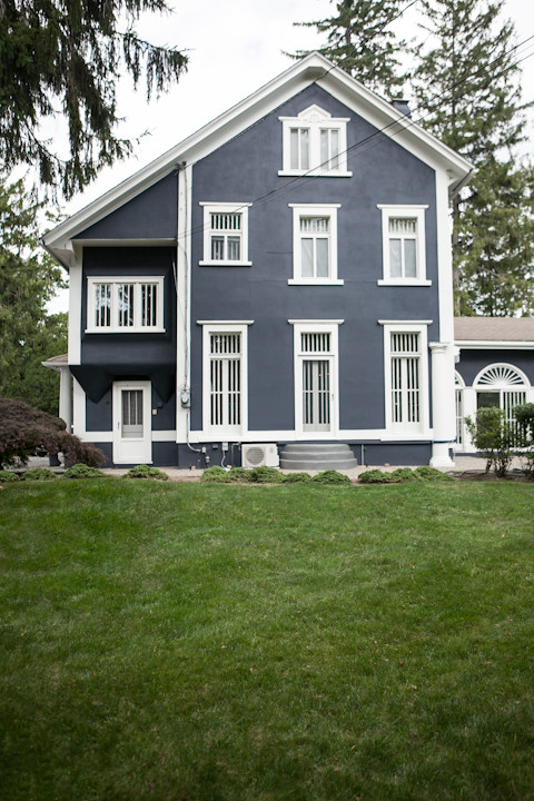 Foto della facciata di una casa grande blu classica a tre piani con rivestimento in stucco