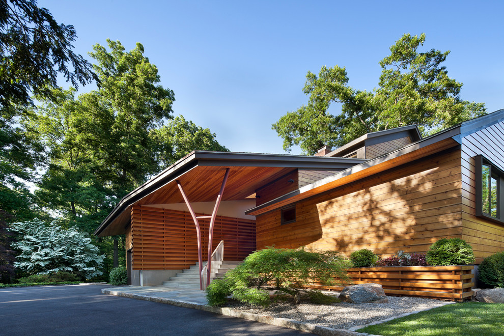 Diseño de fachada marrón contemporánea grande de dos plantas con revestimiento de madera y tejado a dos aguas