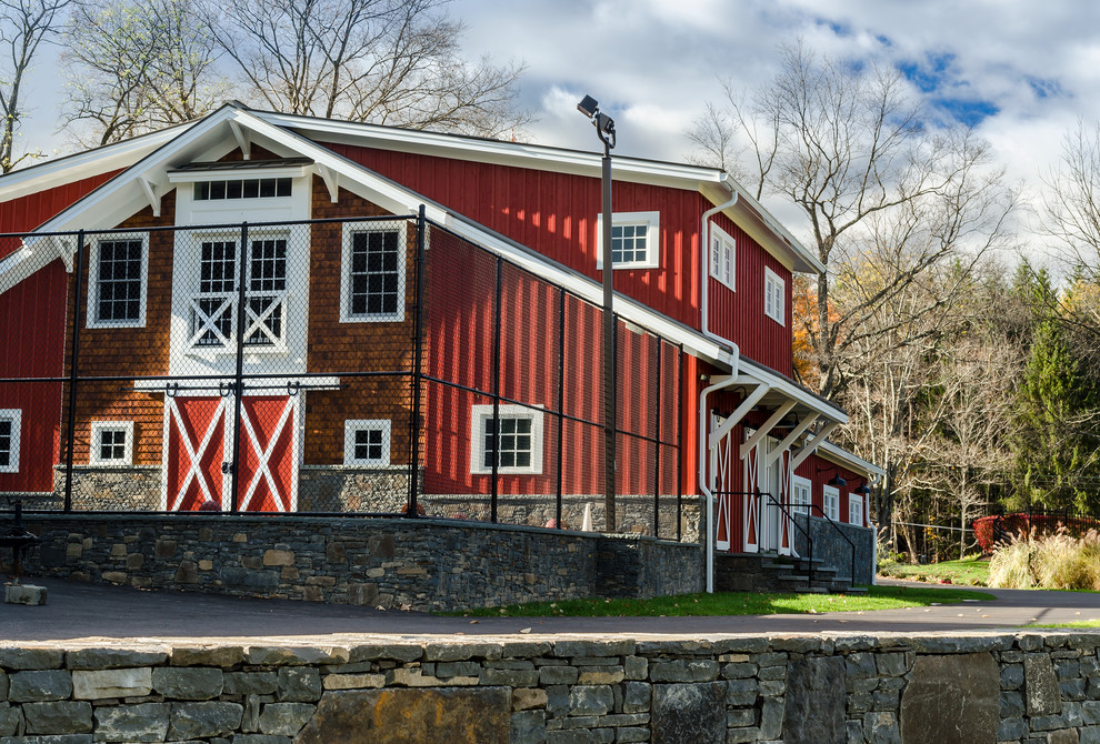 Esempio della facciata di una casa grande rossa country a due piani con rivestimento in legno e tetto a capanna