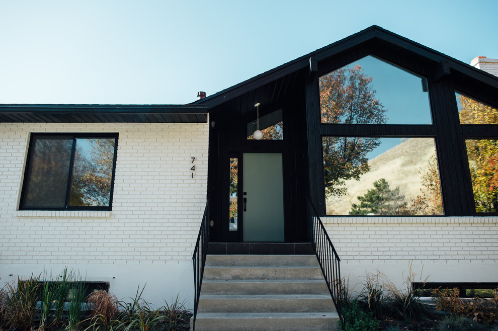 This is an example of a large and white midcentury two floor brick house exterior in Salt Lake City.