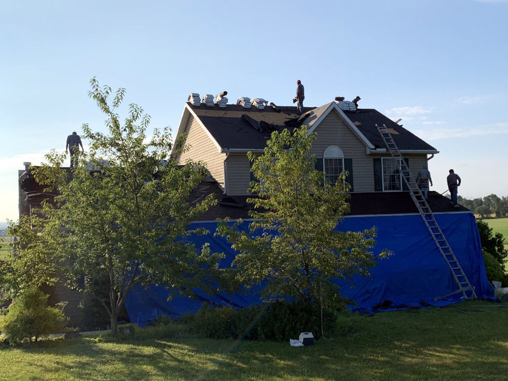 Foto de fachada de casa beige tradicional grande de dos plantas con revestimiento de vinilo, tejado a dos aguas y tejado de teja de madera