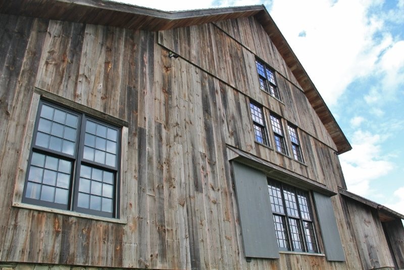 Réalisation d'une grande façade de maison tradition en bois à deux étages et plus avec un toit à deux pans.