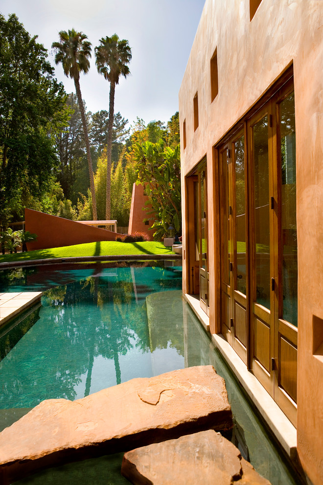 Pool landscaping - large mediterranean backyard stone and custom-shaped natural pool landscaping idea in Los Angeles